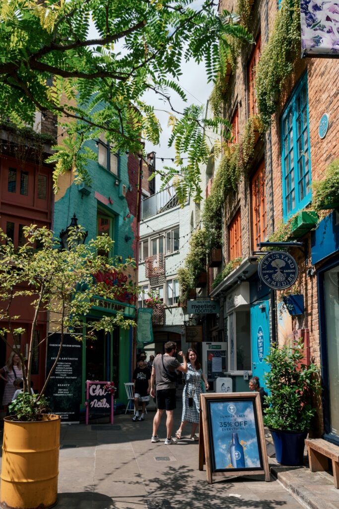Neal’s Yard, Covent Garden – A vibrant courtyard in the heart of London, filled with colorful buildings adorned with lush greenery. People stroll through the alley, enjoying the quirky shops, cozy cafés, and artistic atmosphere, making it a must-visit Instagram hotspot.